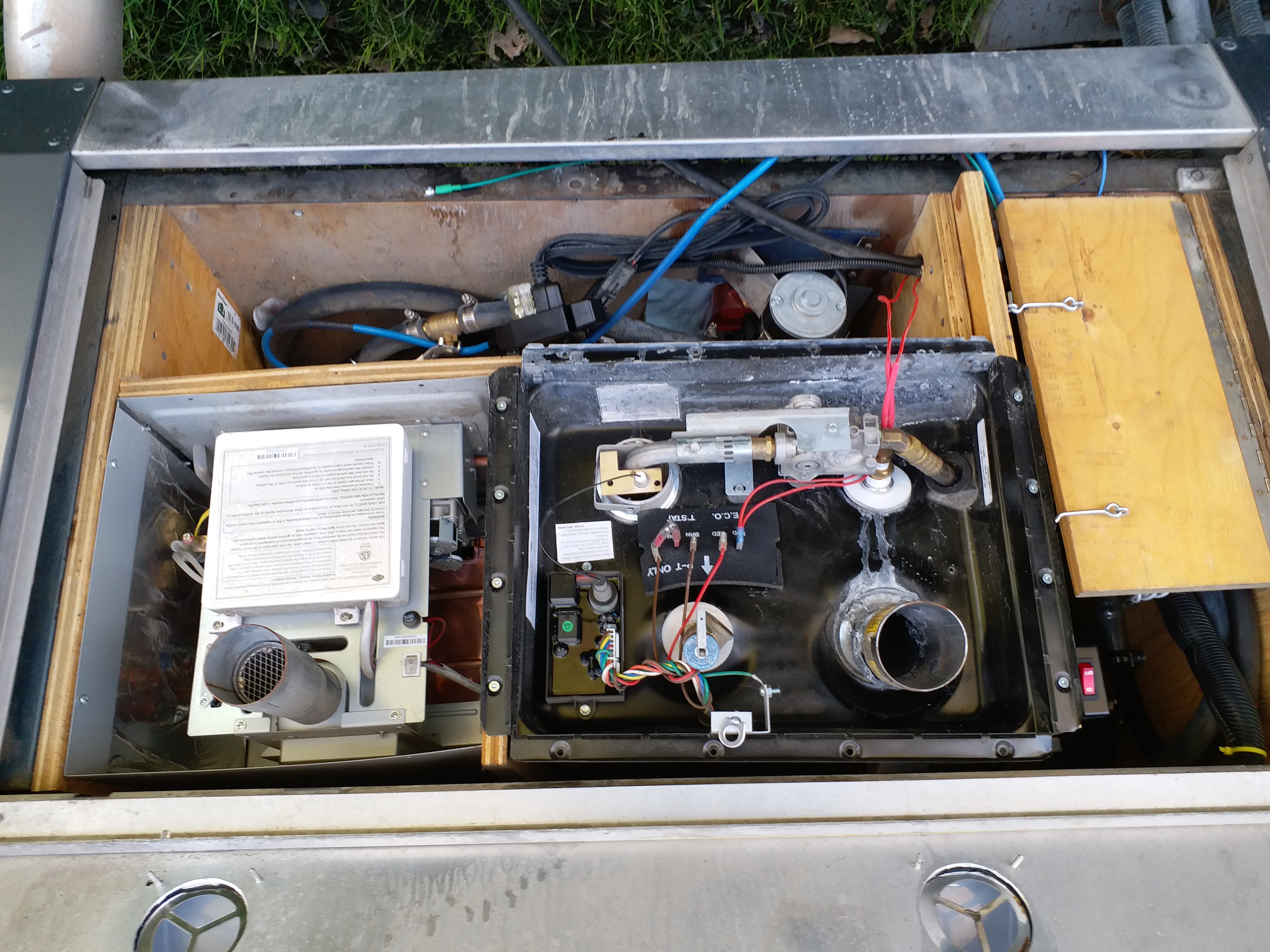 The full compartment where the AquaHot had been The compartment was lined with sheet metal and lined with cement board.  The Girard Tankless is on the right and the Atwood for the hydronic heating on the left.  At the extreme left is a plywood door covering the compartment where hoses and connections are found.